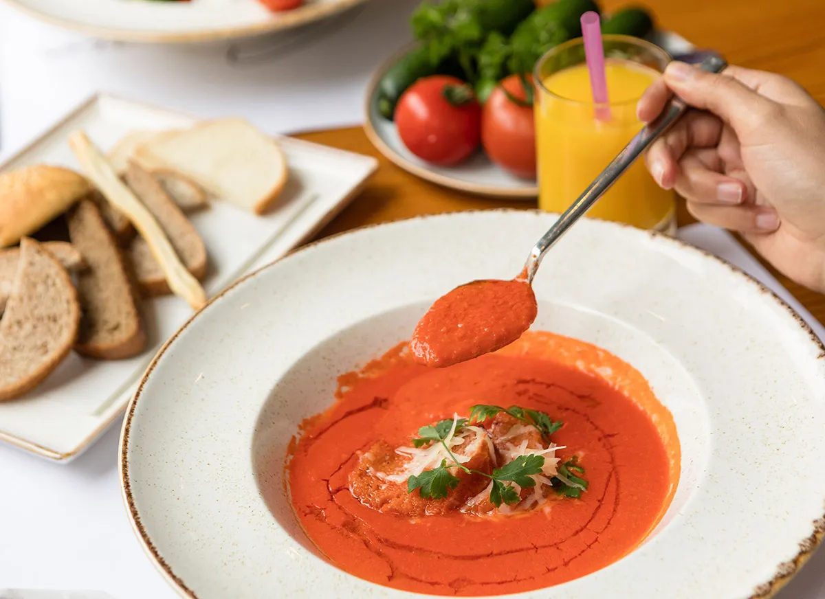 Вкусный томатный суп, подаваемый с свежим хлебом и апельсиновым соком, идеален для питательного приема пищи. Фото: Farhad Ibrahimzade / Pexels. Лицензия: Pexels. Изменения: конвертировано в WebP, изменён размер.